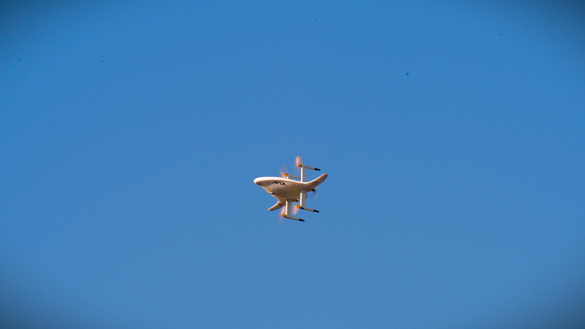 An Avol delivery drone in flight against a clear sky